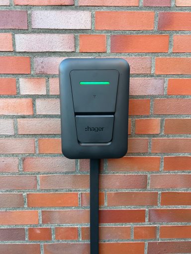 Schwarze Ladestation für Elektroautos an einer Ziegelwand installiert.